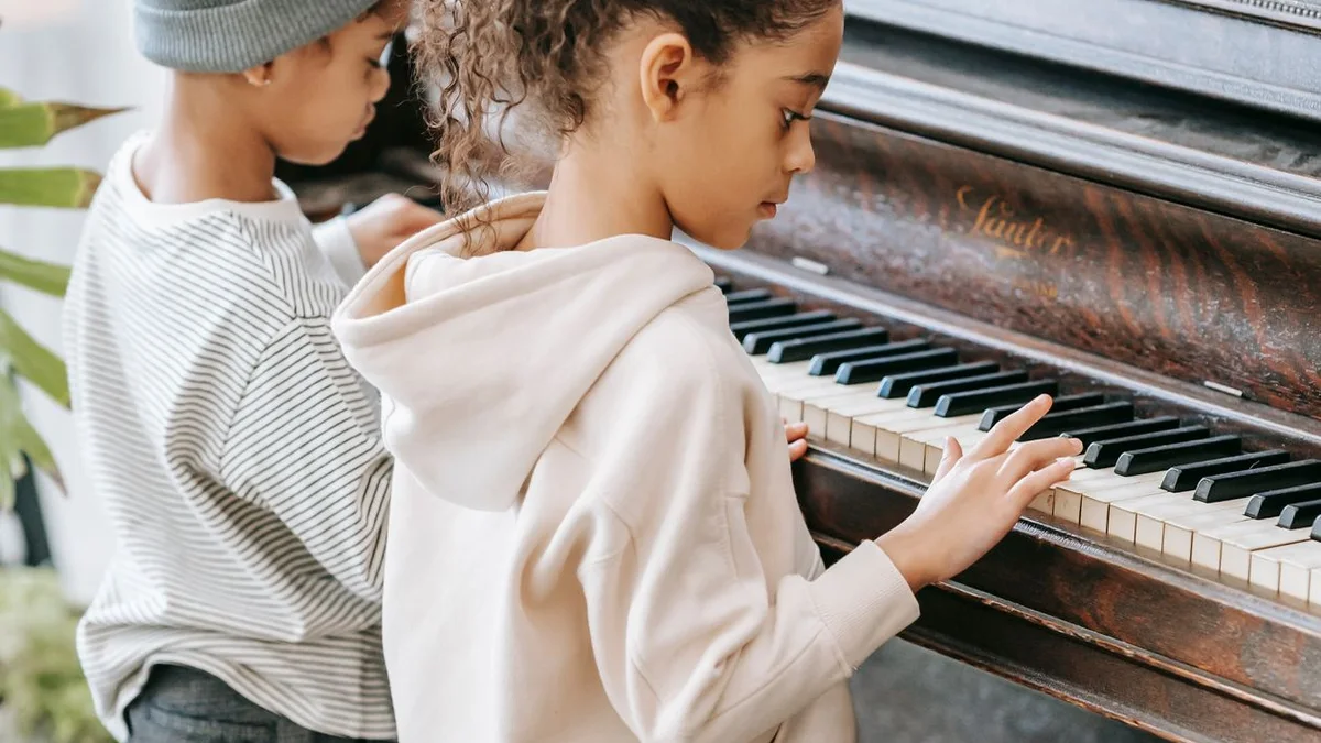 Enfants découvrant le piano avec curiosité - illustration de l'article TCC : thérapie cognitivo-comportementale holistique