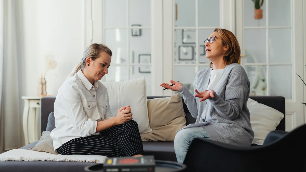 Couple échangeant chaleureusement sur un canapé lumineux - illustration de l'article La programmation neuro-linguistique (PNL)