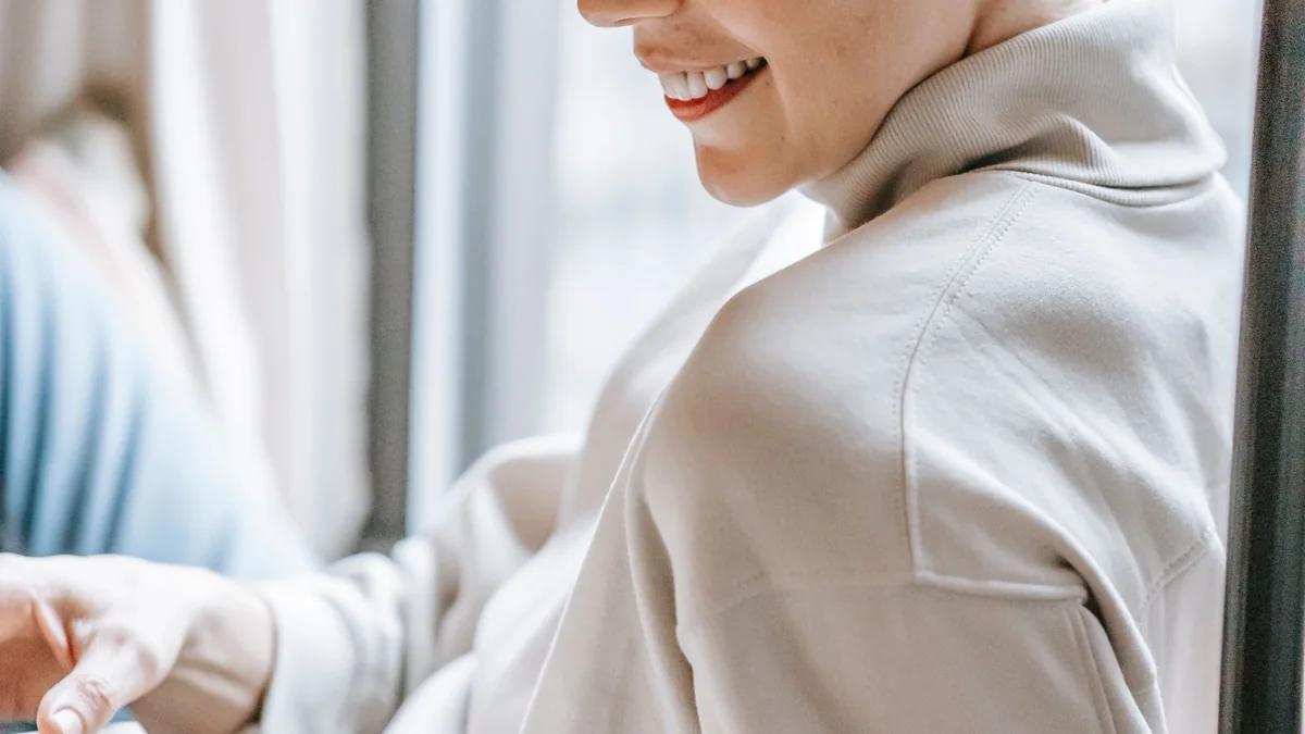 Femme souriante écrivant près d'une fenêtre ensoleillée - illustration de l'article Études de cas et recherche clinique : la science au service de la thérapie