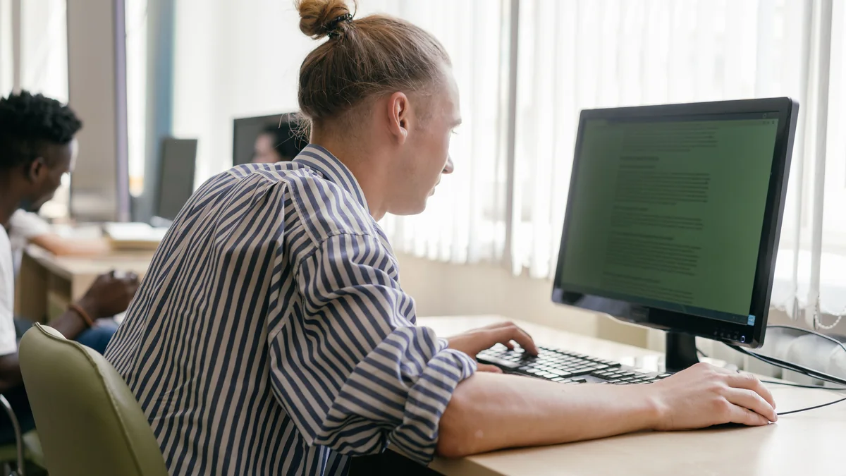 Apprenant concentré devant son écran dans un bureau clair - illustration de l'article Formation certifiante thérapeute de couple