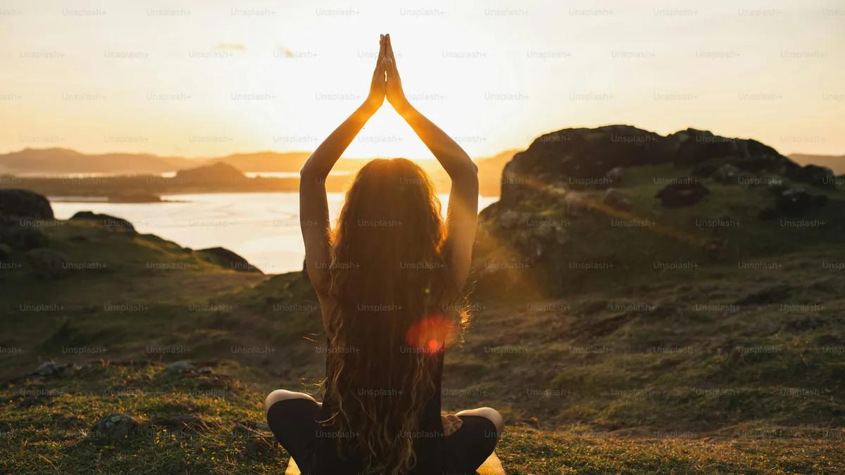 Personne méditant sereinement face au lever du soleil - illustration de l'article Méditation et psychologie