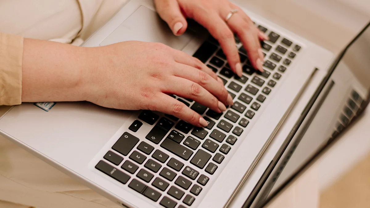 Mains travaillant sur un ordinateur portable dans un bureau clair - illustration de l'article Trouver un thérapeute proche de chez vous