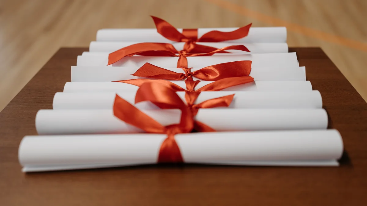 Diplômes roulés fermés par des rubans, symbole de certification - illustration de l'article Devenir thérapeute ou coach de vie sans diplôme : guide complet