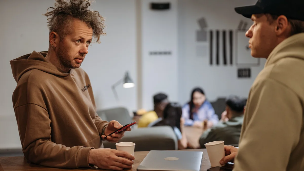 Deux personnes en pleine conversation autour d'un café - illustration de l'article Que fait un ou une thérapeute holistique ?