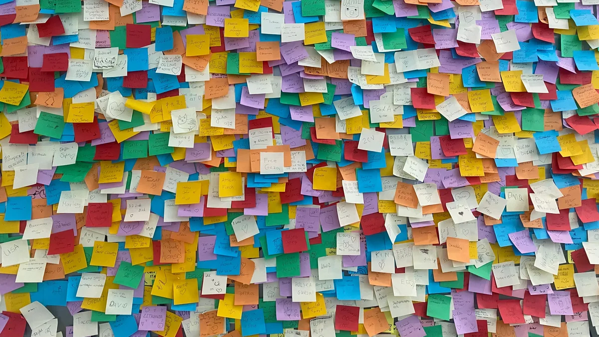 Mur de notes colorées symbolisant le foisonnement d'idées - illustration de l'article Les bienfaits de la créativité pour les thérapeutes et les coachs