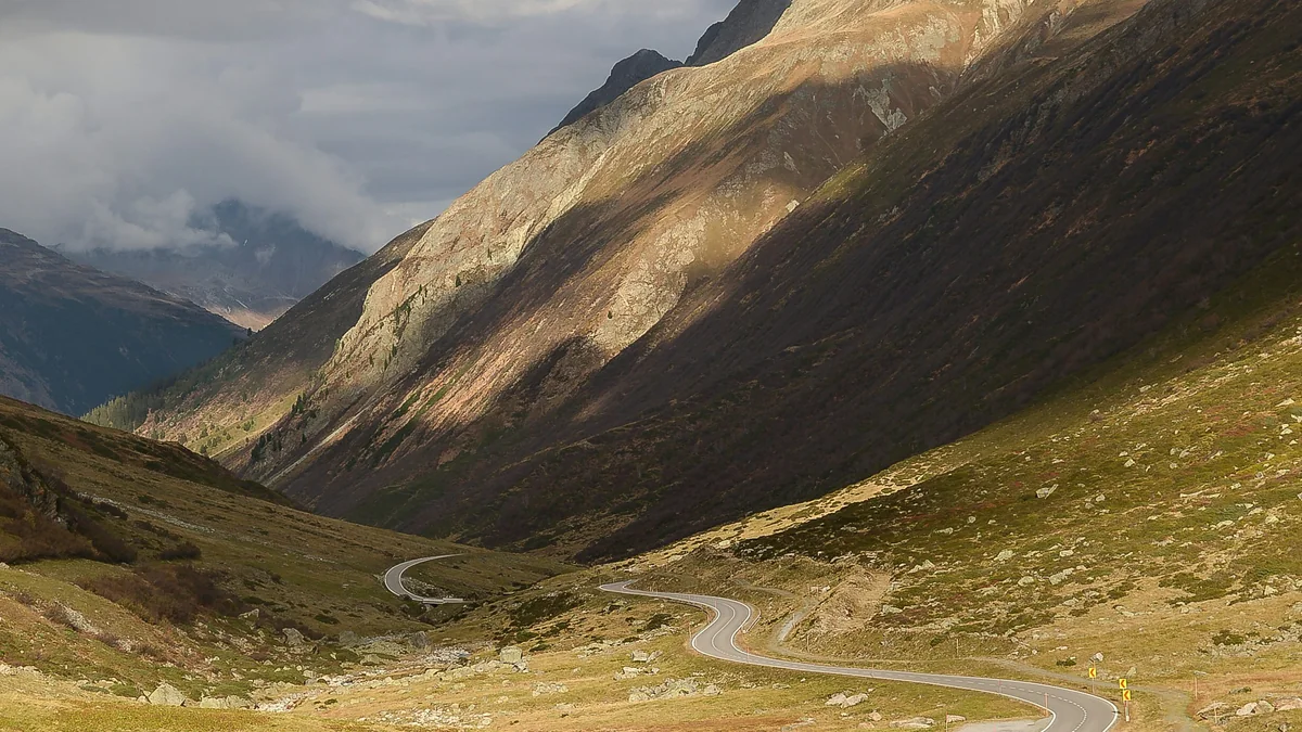 Route sinueuse traversant une vallée verdoyante - illustration de l'article Reconversion, thérapie holistique et burn-out (tech, marketing)