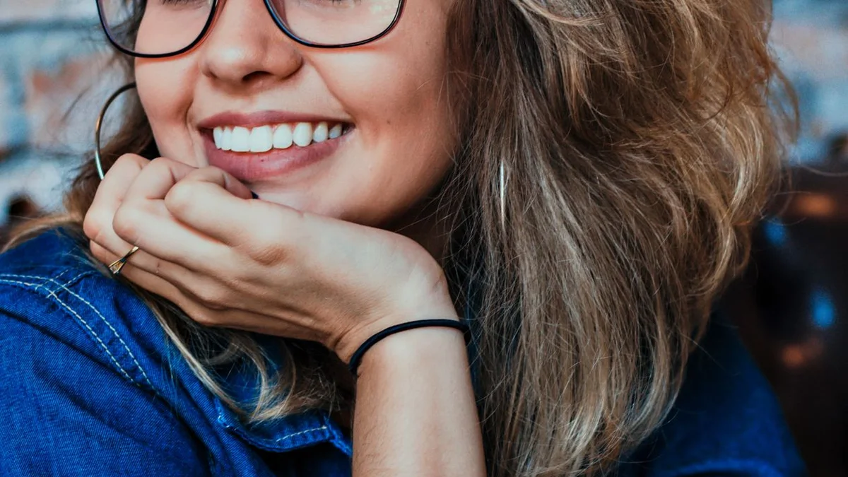 Femme souriante et rayonnante - illustration de l'article Nancy sur la thérapie holistique : définitions et outils